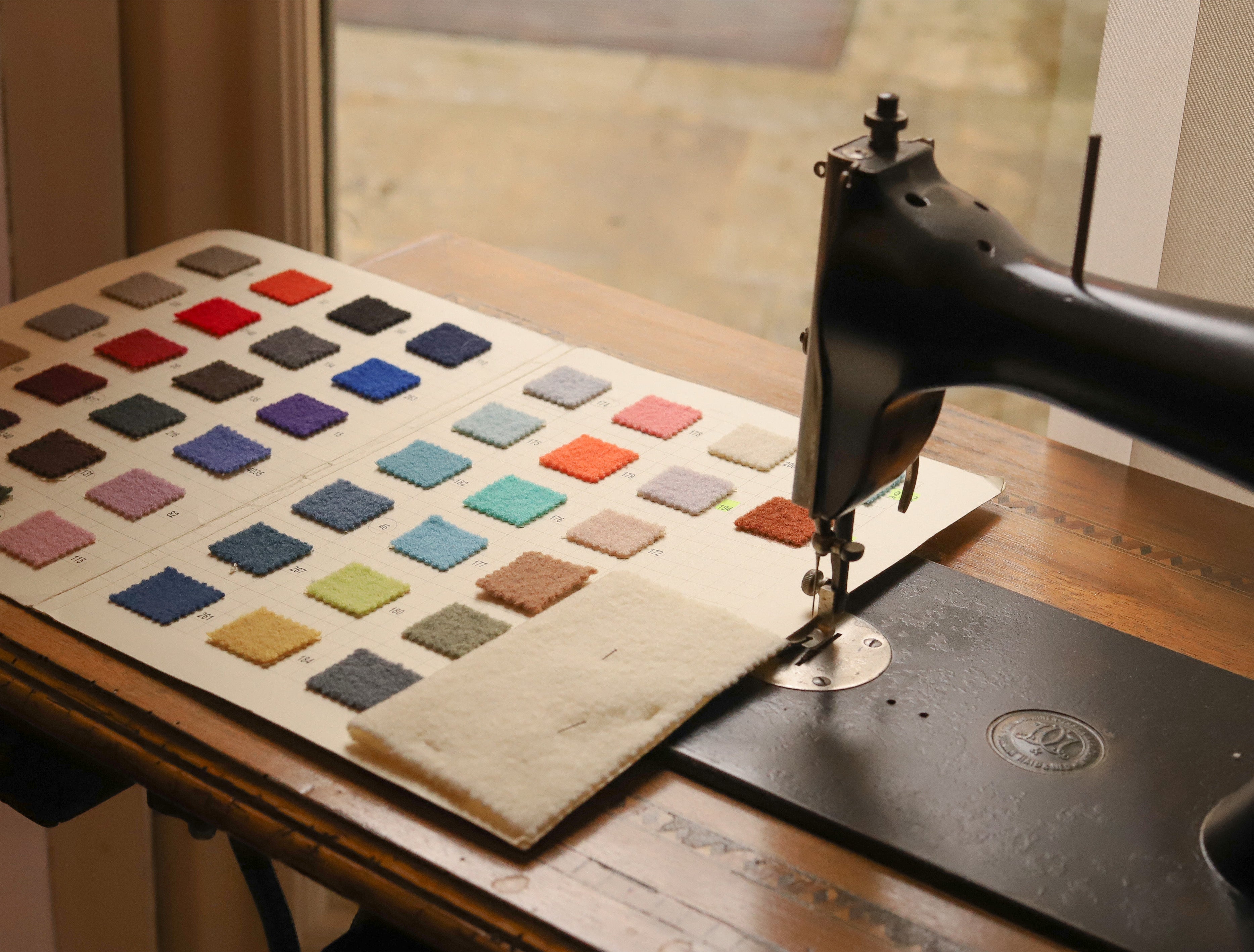 Wool fabric color chart near a sewing machine in Marta Scarampi's atelier
