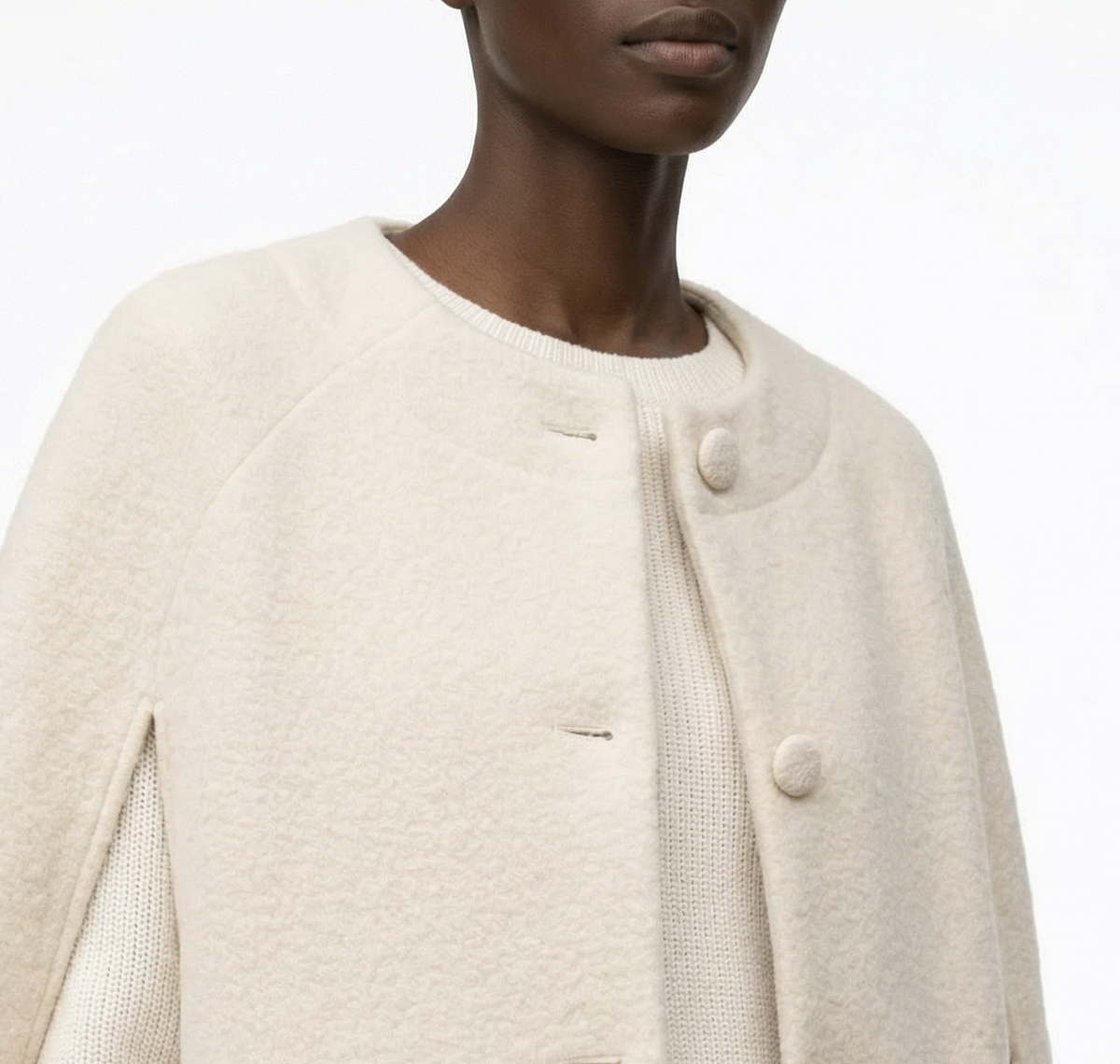 Cream cape worn by a model on a white background