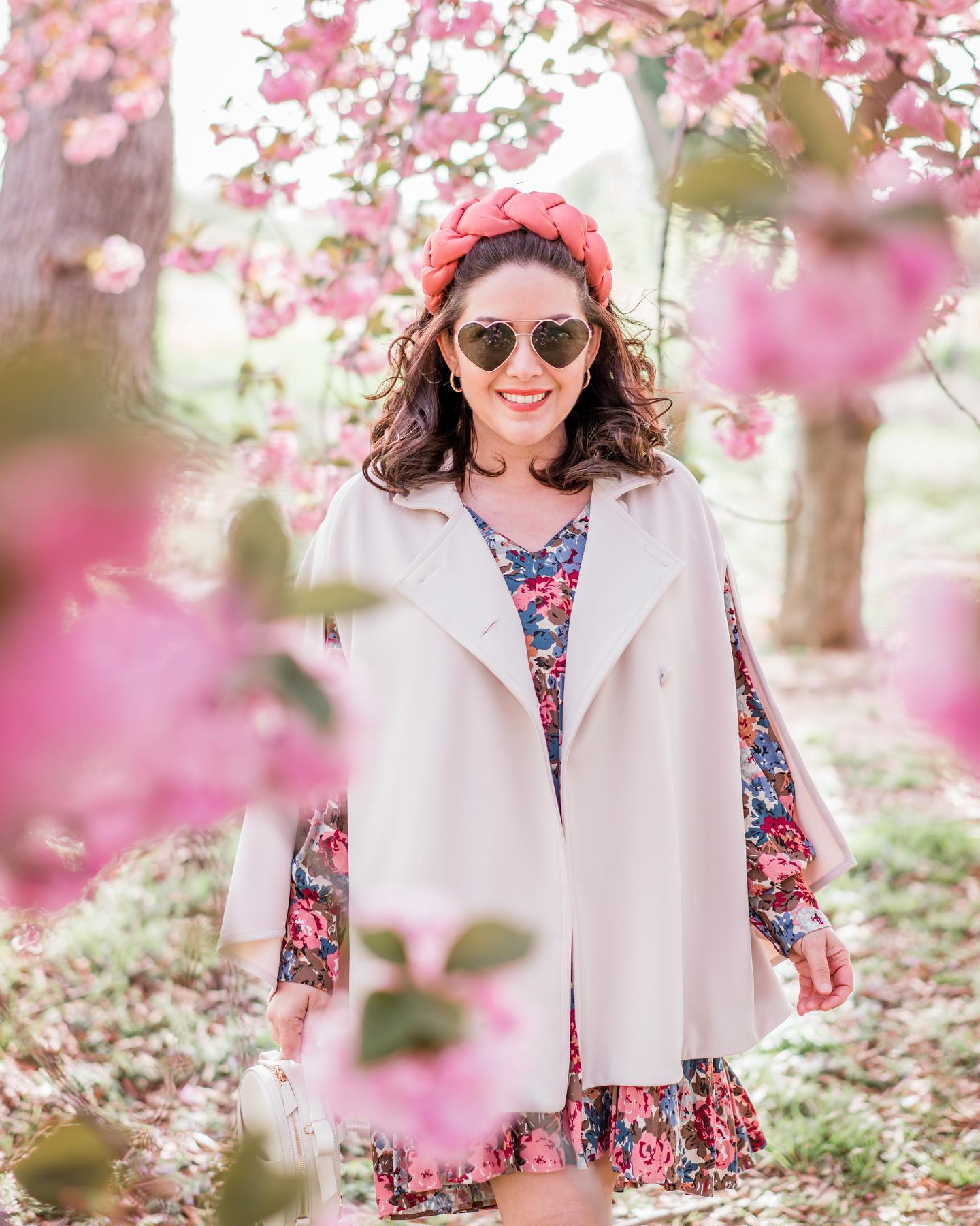 In a beautiful setting of spring flowers, the History in High Hills blogger sports a cream-coloured cape from Marta Scarampi's The Rachel Mondrian. Smiling and full of colour to match the context. 